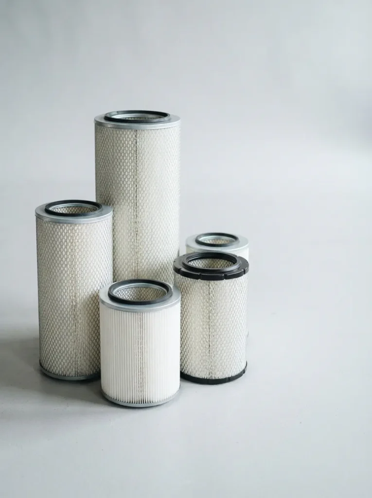 Assorted replacement air filter cartridges in several sizes arranged on a light gray studio surface