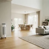 Winix AM90 air purifier in the corner of a large open-plan living and dining room