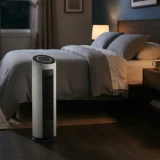 asset_0f82c62711301430 Winix D480 air purifier running on the floor beside a bed at night with a dimmed display