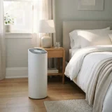 asset_12c580ec10e5c2f9 Winix C535 air purifier running beside a bed in a sunlit bedroom during allergy season