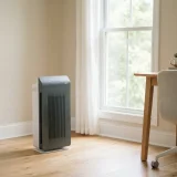 A Winix 5300-2 air purifier running beside a sunlit window in a home office, showing low-profile daily use