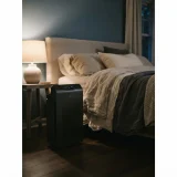 asset_34d31bfd86421d4b Winix 9800 air purifier standing beside a bed in a dimly lit evening bedroom