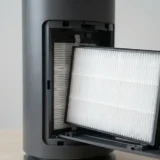 asset_3e7a2f5f9504241d Close-up of a pleated Winix D480 True HEPA filter half slid out of the unit's filter bay