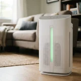 asset_4d039b9ba149dd62 Close view of the Winix C545 air purifier front LED air quality indicator glowing green in a living room