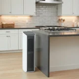 asset_54546da55b9fba9b Winix D480 air purifier on a kitchen floor beside an island while a pan sits on the stovetop