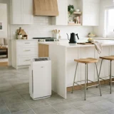 asset_56194afb4f840b27 Winix C545 air purifier standing on a kitchen floor beside an island with bar stools