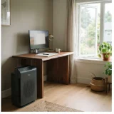 Winix 5500-2 air purifier beside a desk by an open window in a home office