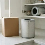 A new Winix Filter Z canister beside its plain box on a counter, with a second canister stored in a cabinet