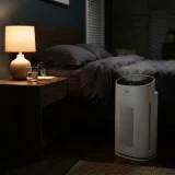asset_ba063354e31599dd Winix C535 air purifier on low speed beside a bedside table in a dim bedroom at night