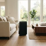 Winix 5510 air purifier standing between a linen sofa and a coffee table in an open family room