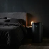 asset_cf55feac7eacbf6c Air purifier glowing softly beside a bed at night
