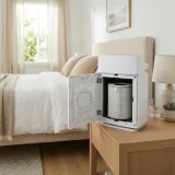 asset_e33c1dda3145ce7a Winix C610 air purifier with a fresh Filter Z canister running beside a bed in morning light