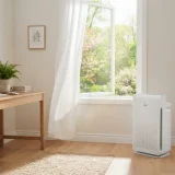 Winix Zero air purifier beside an open window in a sunlit home office in spring