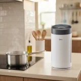 Winix 5520 air purifier standing on a kitchen counter beside a pot on the stove