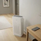 asset_fe1eeef22c1c4ad8 Winix C545 air purifier in a hallway with an unbranded smartphone resting on a console table